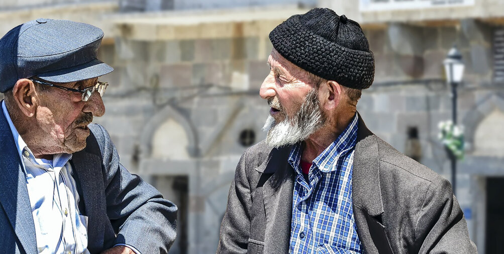 Oudere Turkse mannen praten op straat