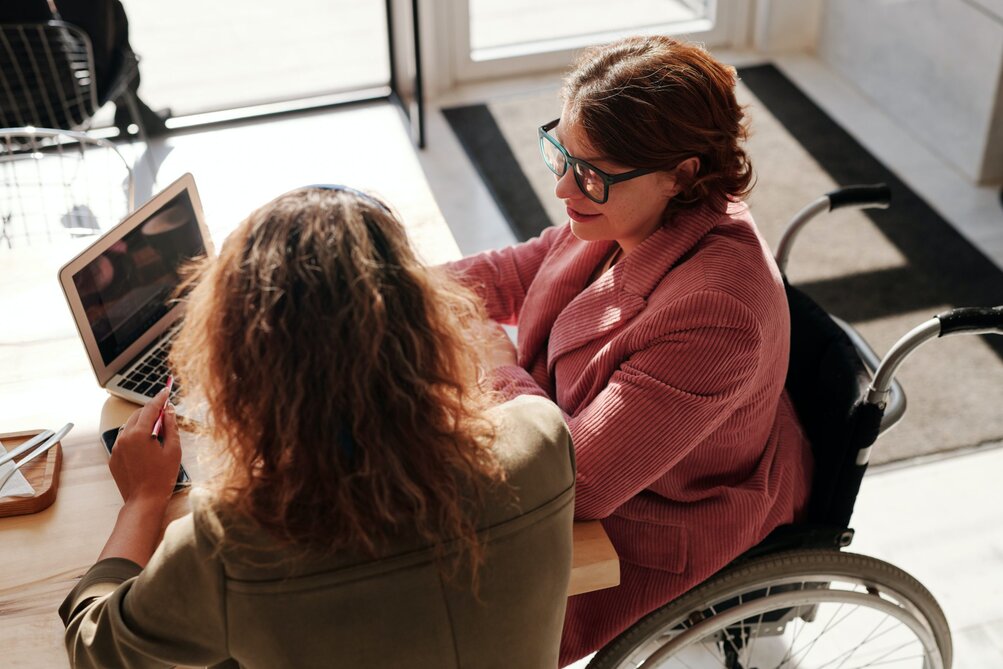 Vrouw in rolstoel met laptop