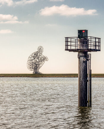 'De hurkende man', kunstwerk van Antony Gormley op de Markerstrekdam in Lelystad.