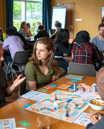 Deelnemers spelen in groepjes het samenspel Buurtgenoten.