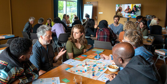 Deelnemers spelen in groepjes het samenspel Buurtgenoten.