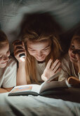 Een moeder leest haar kinderen voor.